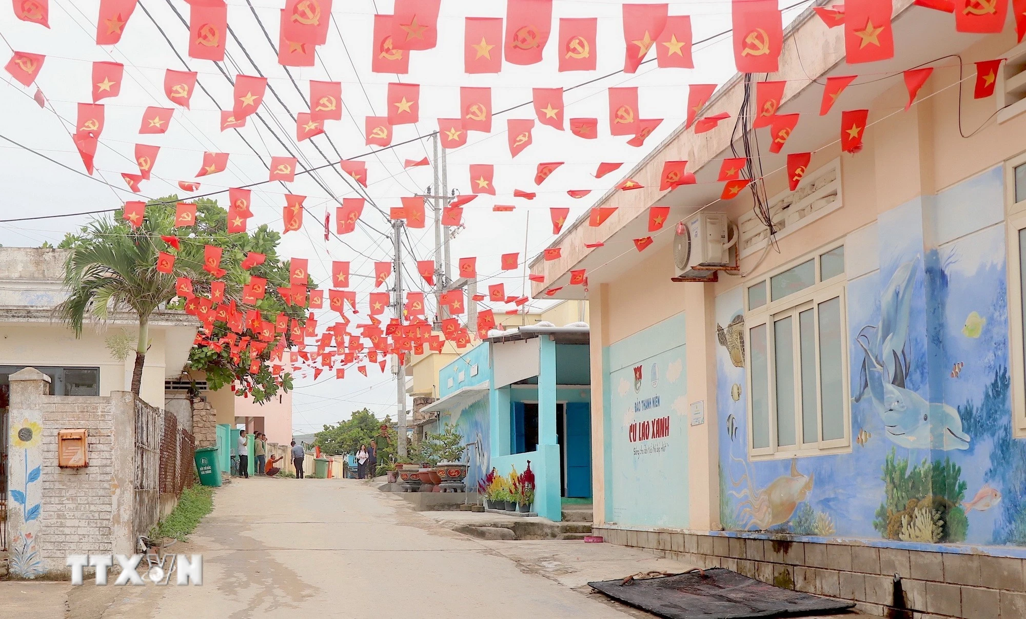 Những con hẻm nhỏ trên xã đảo Nhơn Châu được trang hoàng cờ hoa rực rỡ. (Ảnh: Quang Thái/TTXVN)
