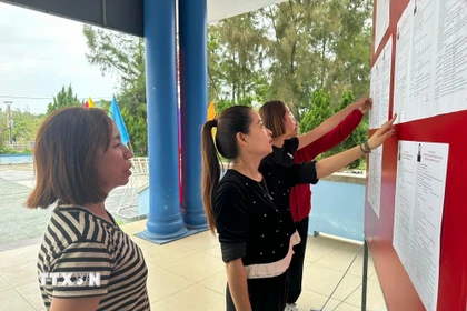 Cử tri xem bảng niêm yết danh sách chính thức, tiểu sử tóm tắt những người ứng cử đại biểu Quốc hội khóa XVI và đại biểu Hội đồng Nhân dân tỉnh Quảng Trị nhiệm kỳ 2026-2031. (Ảnh: TTXVN phát)