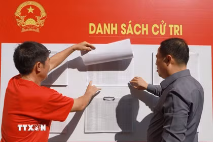 Cử tri phường Nam Nha Trang, tỉnh Khánh Hòa xem danh sách cử tri niêm yết tại khu vực bỏ phiếu bầu cử. (Ảnh: Xuân Triệu/TTXVN)