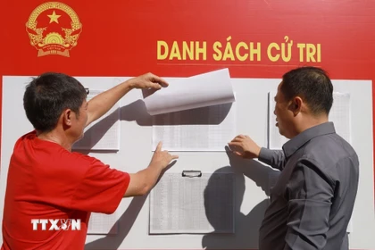 Cử tri phường Nam Nha Trang, tỉnh Khánh Hòa xem danh sách cử tri niêm yết tại khu vực bỏ phiếu bầu cử. (Ảnh: Xuân Triệu/TTXVN)