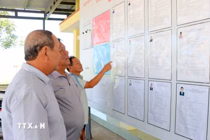 Cử tri ở thôn Văn Lâm 2 (xã Thuận Nam, tỉnh Khánh Hòa tìm hiểu tóm tắt tiểu sử người ứng cử tại đơn vị bầu cử số 3, khu vực bỏ phiếu số 5. (Ảnh: Công Thử/TTXVN)