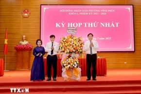 Chủ tịch UBND tỉnh, Phó Bí thư Tỉnh ủy Phú Thọ Trần Duy Đông (phải) tặng hoa chúc mừng lãnh đạo phường Vĩnh Phúc tại kỳ họp. (Ảnh: Hoàng Hùng/TTXVN)
