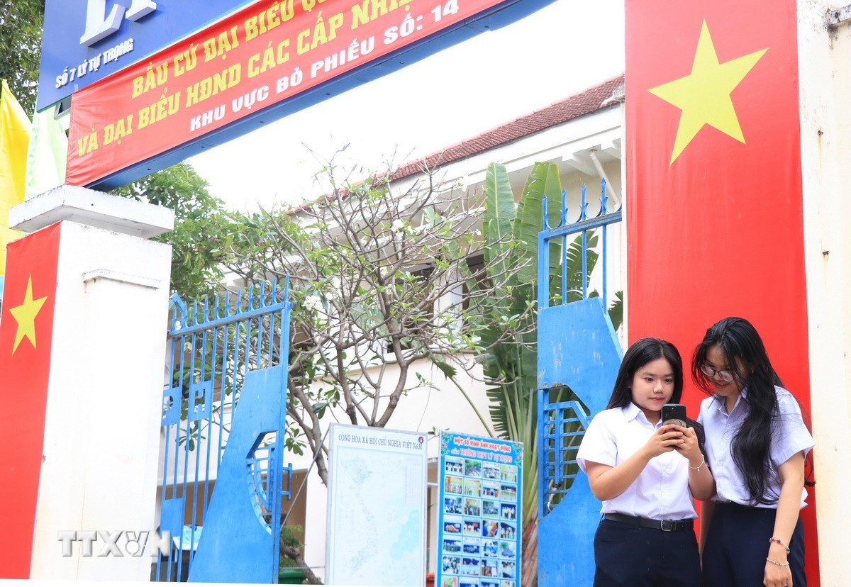 Cử tri đủ tròn 18 tuổi học tại Trường THPT Lý Tự Trọng, phường Nha Trang, tỉnh Khánh Hòa tìm hiểu thông tin về các ứng cử viên trên không gian số. (Ảnh: Phan Sáu/TTXVN)