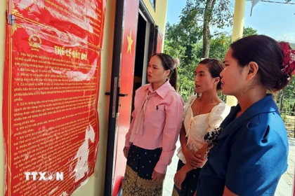 Đồng bào Bru - Vân Kiều (xã Trường Sơn, Quảng Trị) đọc các quy định về công tác bầu cử. (Ảnh: TTXVN phát)