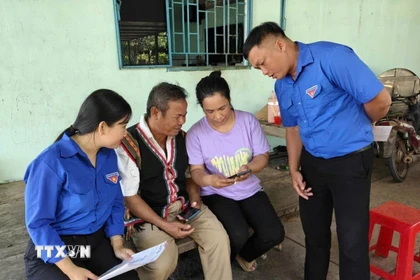Đoàn thanh niên xã Tân Khai tuyên truyền hướng dẫn truy cập vào điện thoại thông tin bầu cử trong vùng đồng bào thiểu số. (Ảnh: K GỬIH/TTXVN)