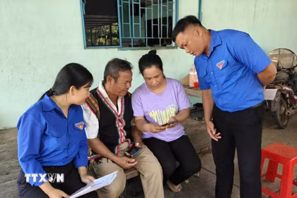 Đoàn thanh niên xã Tân Khai tuyên truyền hướng dẫn truy cập vào điện thoại thông tin bầu cử trong vùng đồng bào thiểu số. (Ảnh: K GỬIH/TTXVN)