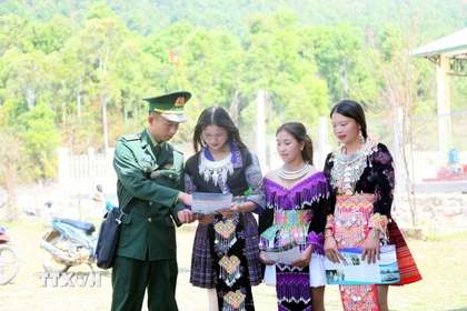 Cán bộ Đồn Biên phòng Mường Lèo (Ban Chỉ huy Bộ đội Biên phòng tỉnh Sơn La) tuyên truyền, vận động đồng bào dân tộc Mông ở bản Sam Quảng đi bầu cử. (Ảnh: Quang Quyết/TTXVN)