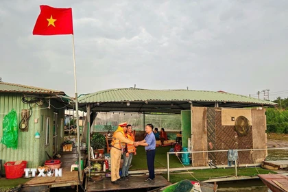 Đội Cảnh sát đường thủy số 2, Phòng Cảnh sát giao thông (Công an thành phố Hà Nội) đi từng xóm, đón từng thuyền, phát thẻ cử tri cho người dân trên sông Hồng. (Ảnh: TTXVN phát)