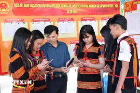 Đồng bào Xơ Đăng (xã Trà Linh, thành phố Đà Nẵng) theo dõi trên điện thoại các video clip, inforgraphic hướng dẫn cách thức đi bỏ phiếu. (Ảnh: Trần Tĩnh/TTXVN)