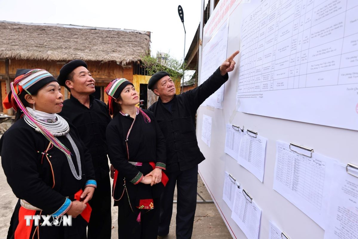 Cử tri xem danh sách đại biểu ứng cử được niêm yết công khai tại nhà văn hóa thôn Nặm Đăm, xã Quản Bạ. (Ảnh: Minh Đức/TTXVN)