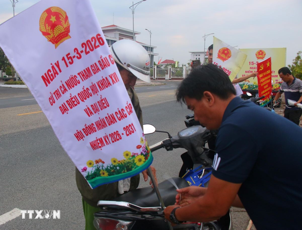 Gắn thông tin tuyên truyền bằng xe gắn máy trên địa bàn xã Vĩnh Viễn, thành phố Cần Thơ. (Ảnh: Duy Khương/TTXVN)