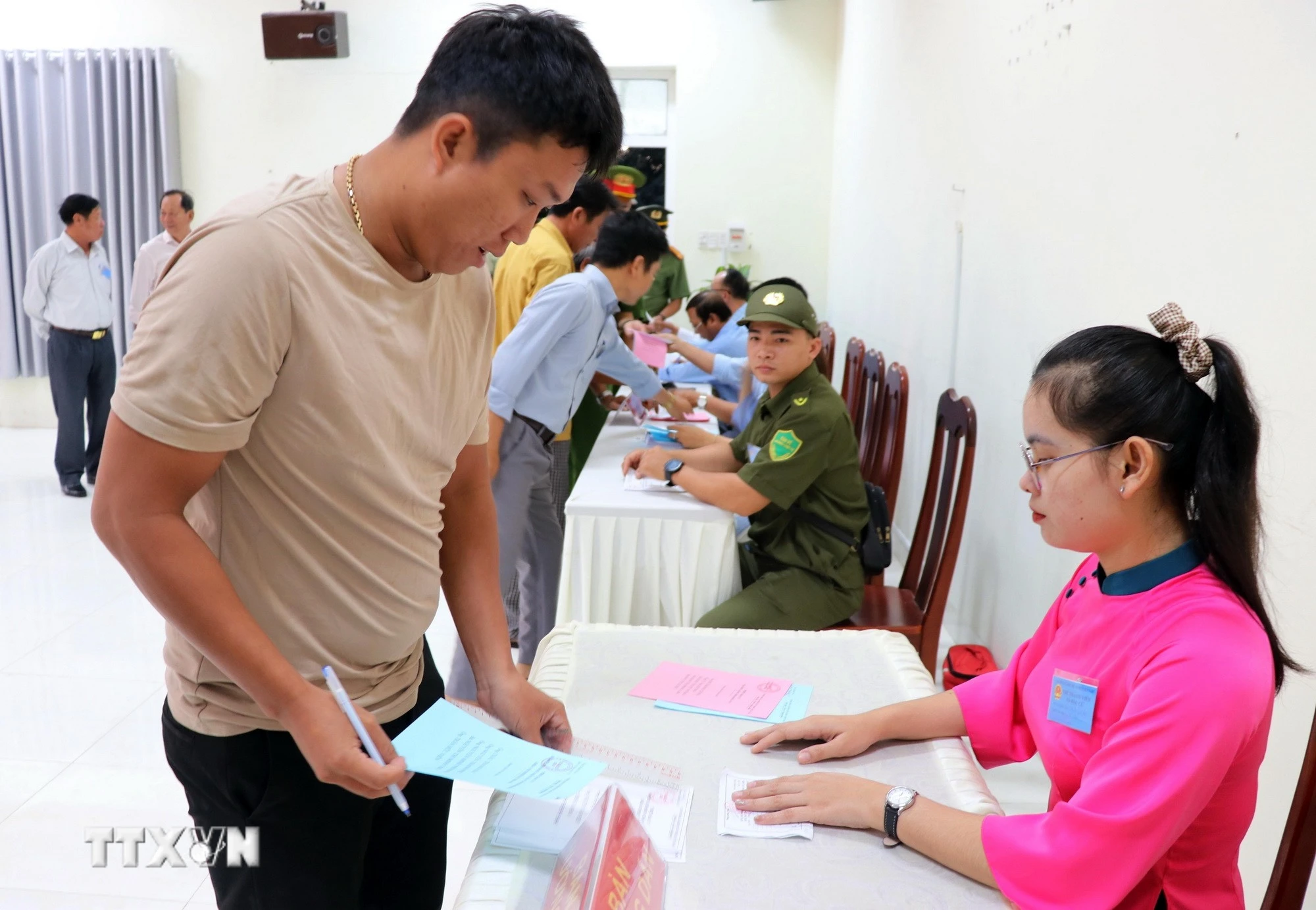 Thành viên Tổ bầu cử số 6 (xã Cà Ná) phát phiếu bầu cho cư tri thực hiện quyền công dân của mình. (Ảnh: Công Thử/TTXVN)