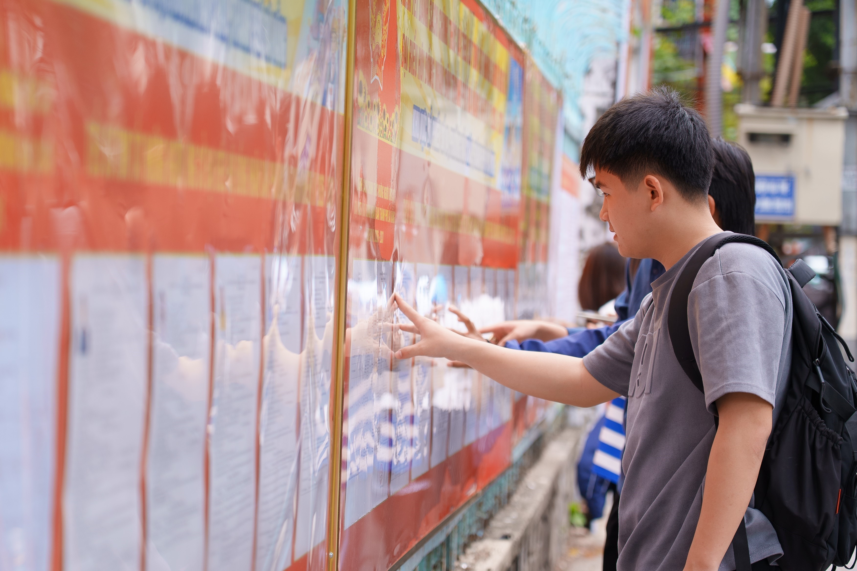 Người dân nghiên cứu danh sách các ứng cử viên được niêm yết tại các điểm bầu cử. (Ảnh: Khoa Chương/TTXVN)