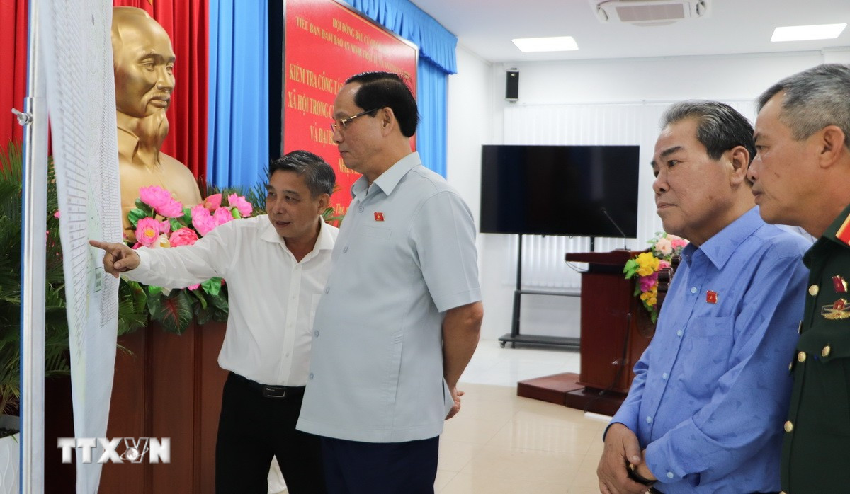 Phó Chủ tịch Quốc hội Trần Quang Phương kiểm tra bản đồ các điểm bầu cử trên địa bàn thành phố. (Ảnh: Hồng Thái/TTXVN)