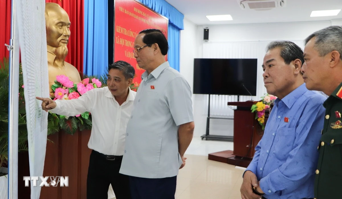 Phó Chủ tịch Quốc hội Trần Quang Phương kiểm tra bản đồ các điểm bầu cử trên địa bàn thành phố. (Ảnh: Hồng Thái/TTXVN)