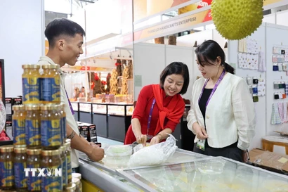 Đại diện doanh nghiệp Việt Nam giới thiệu sản phẩm bánh sầu riêng Việt Nam. (Ảnh: Công Tuyên/TTXVN)