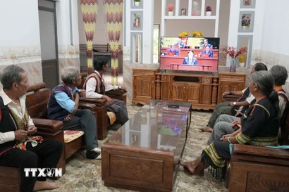 Già làng, người có uy tín và bà con làng Plei Jơ Drơp, xã Ia Chim, tỉnh Quảng Ngãi theo dõi phiên khai mạc Đại hội lần thứ XIV của Đảng. (Ảnh: Cao Nguyên/TTXVN)