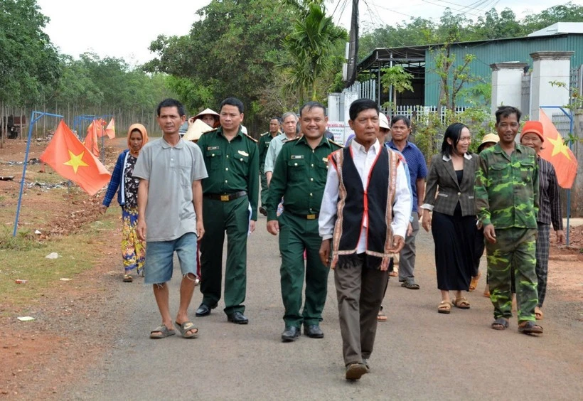 Già làng, người có uy tín trong cộng đồng và lực lượng biên phòng “đi từng ngõ, gõ từng nhà” để hướng dẫn người dân quy trình bỏ phiếu bầu cử đúng theo quy định. (Ảnh: Hồng Điệp/TTXVN)