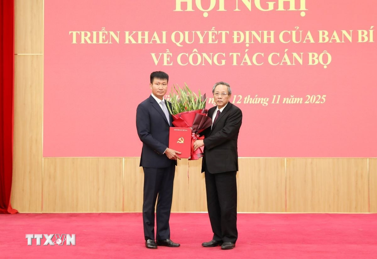 Đồng chí Hoàng Đăng Quang (phải), Ủy viên Trung ương Đảng, Phó Trưởng ban Thường trực Ban Tổ chức Trung ương, trao quyết định cho đồng chí Trần Huy Tuấn giữ chức Phó Bí thư Tỉnh ủy Ninh Bình. (Ảnh: Đức Phương/TTXVN)