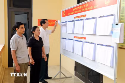 Người dân theo dõi danh sách cử tri tại Khu vực bỏ phiếu số 1, xã Gia Viễn, tỉnh Ninh Bình. (Ảnh: Thùy Dung/TTXVN)