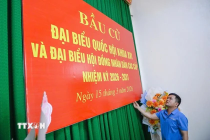 Thực hiện công tác trang trí tại khu vực bỏ phiếu Nhà văn hóa thôn Minh Hùng, xã Vạn Lộc. (Ảnh: Hoa Mai/TTXVN)