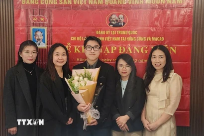 Nguyễn Thị Xuân Huệ (thứ hai, bên trái), nghiên cứu sinh chuyên ngành Ngôn ngữ học ứng dụng tiếng Anh tại Đại học Macau (Trung Quốc), Bí thư Chi bộ Lưu học sinh Việt Nam tại Hong Kong và Macau tại lễ kết nạp đảng viên mới. (Nguồn: TTXVN phát)