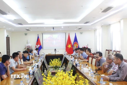 Các đảng viên thuộc Chi bộ Khối Văn phòng Đại sứ quán và Chi bộ phu nhân - phu quân theo dõi truyền hình trực tiếp Lễ khai mạc Đại hội XIV của Đảng tại Đại sứ quán Việt Nam ở thủ đô Phnom Penh. (Ảnh: Hoàng Minh/TXTVN)