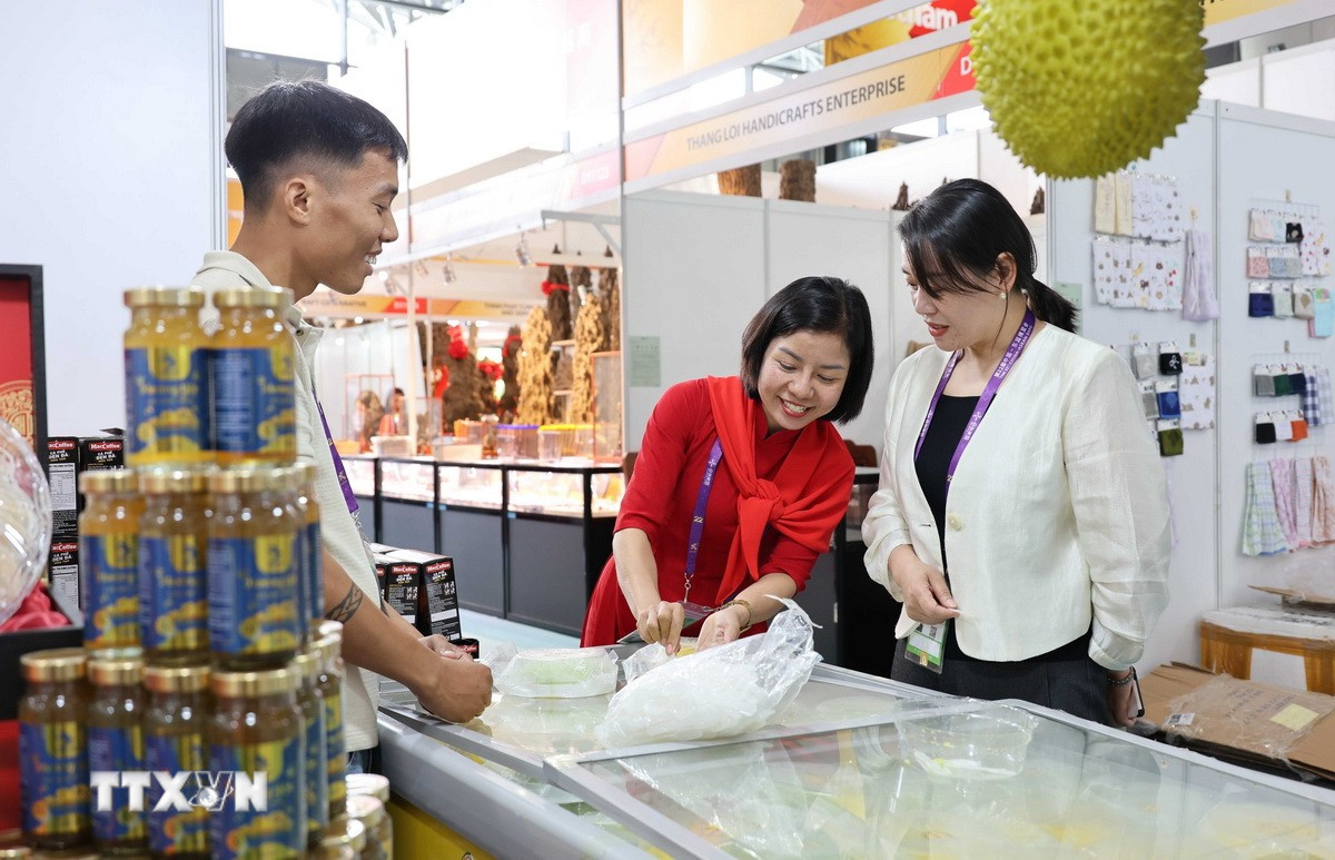 Đại diện doanh nghiệp Việt Nam giới thiệu sản phẩm bánh sầu riêng Việt Nam. (Ảnh: Công Tuyên/TTXVN)