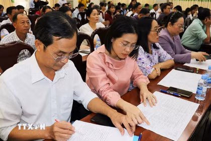 Các đại biểu nghiên cứu tiểu sử trích ngang các ứng cử viên đại biểu Quốc hội khóa XVI. (Ảnh: Hữu Chí/TTXVN)