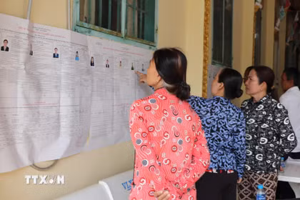 Đồng bào Khmer ấp Ngã Cạy, xã Xà Phiên tìm hiểu thông tin về ứng cử viên đại biểu Quốc hội và Hội đồng Nhân dân được niêm yết tại chùa Bôrâysarâychum. (Ảnh: Hồng Thái/TTXVN)