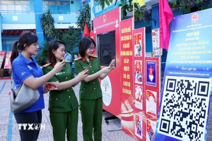 Cử tri trẻ Thành phố Hồ Chí Minh quét mã QR để tham gia cuộc thi tìm hiểu về Luật Bầu cử trực tuyến. (Ảnh: Xuân Khu/TTXVN)