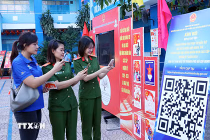 Cử tri trẻ Thành phố Hồ Chí Minh quét mã QR để tham gia cuộc thi tìm hiểu về Luật Bầu cử trực tuyến. (Ảnh: Xuân Khu/TTXVN)