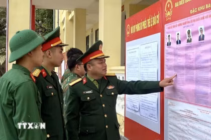 Cán bộ, chiến sỹ Tiểu đoàn phòng thủ đảo Bạch Long Vĩ đang xem tiểu sử tóm tắt những người ứng cử đại biểu Quốc hội khóa XVI. (Ảnh: TTXVN phát)