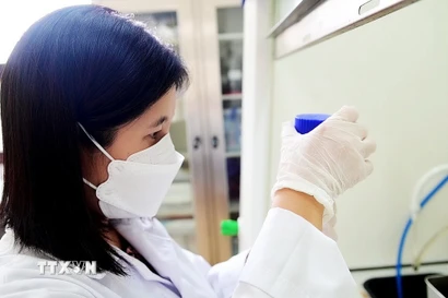 Tiến sỹ Trần Thị Kim Chi nghiên cứu tại phòng thí nghiệm của Viện Khoa học vật liệu. (Ảnh: Diệu Thúy/TTXVN)