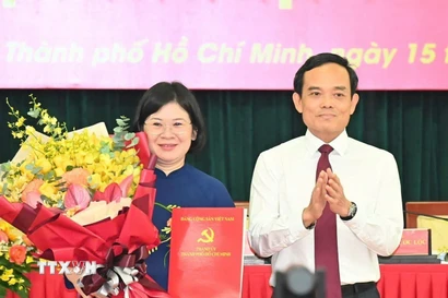Bí thư Trung ương Đảng, Bí thư Thành ủy Thành phố Hồ Chí Minh Trần Lưu Quang trao quyết định cho đồng chí Văn Thị Bạch Tuyết. (Ảnh: TTXVN phát)