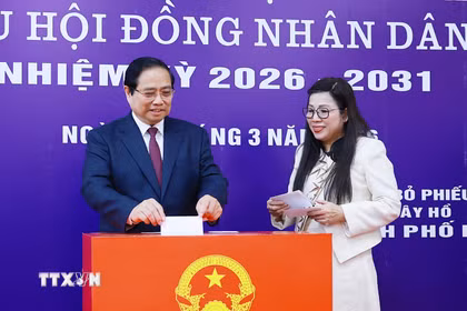 Thủ tướng Phạm Minh Chính và Phu nhân bỏ phiếu bầu tại Khu vực bỏ phiếu số 21, phường Tây Hồ, thành phố Hà Nội. (Ảnh: Dương Giang/TTXVN)