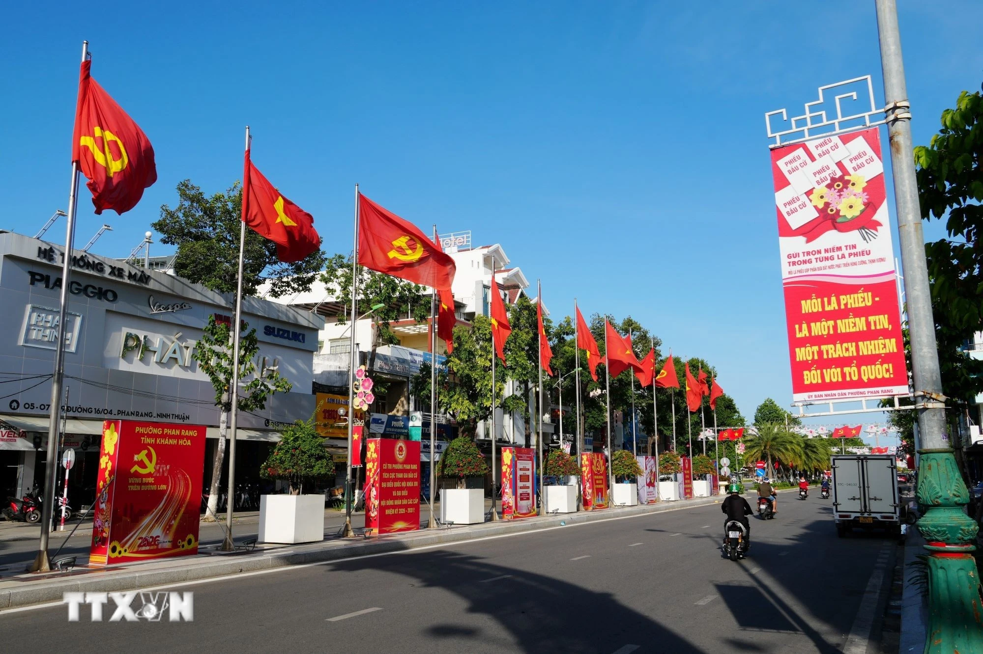 Cờ, hoa và panô tuyên truyền về cuộc bầu cử đại biểu Quốc hội khóa XVI và đại biểu Hội đồng nhân dân các cấp nhiệm kỳ 2026-2031 được trang trí trên tuyến đường 16 tháng 4 phường Phan Rang (Khánh Hòa). (Ảnh: Nguyễn Thành/TTXVN)