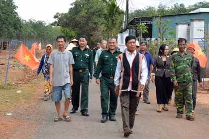 Già làng, người có uy tín trong cộng đồng và lực lượng biên phòng “đi từng ngõ, gõ từng nhà” để hướng dẫn người dân quy trình bỏ phiếu bầu cử đúng theo quy định. (Ảnh: Hồng Điệp/TTXVN)