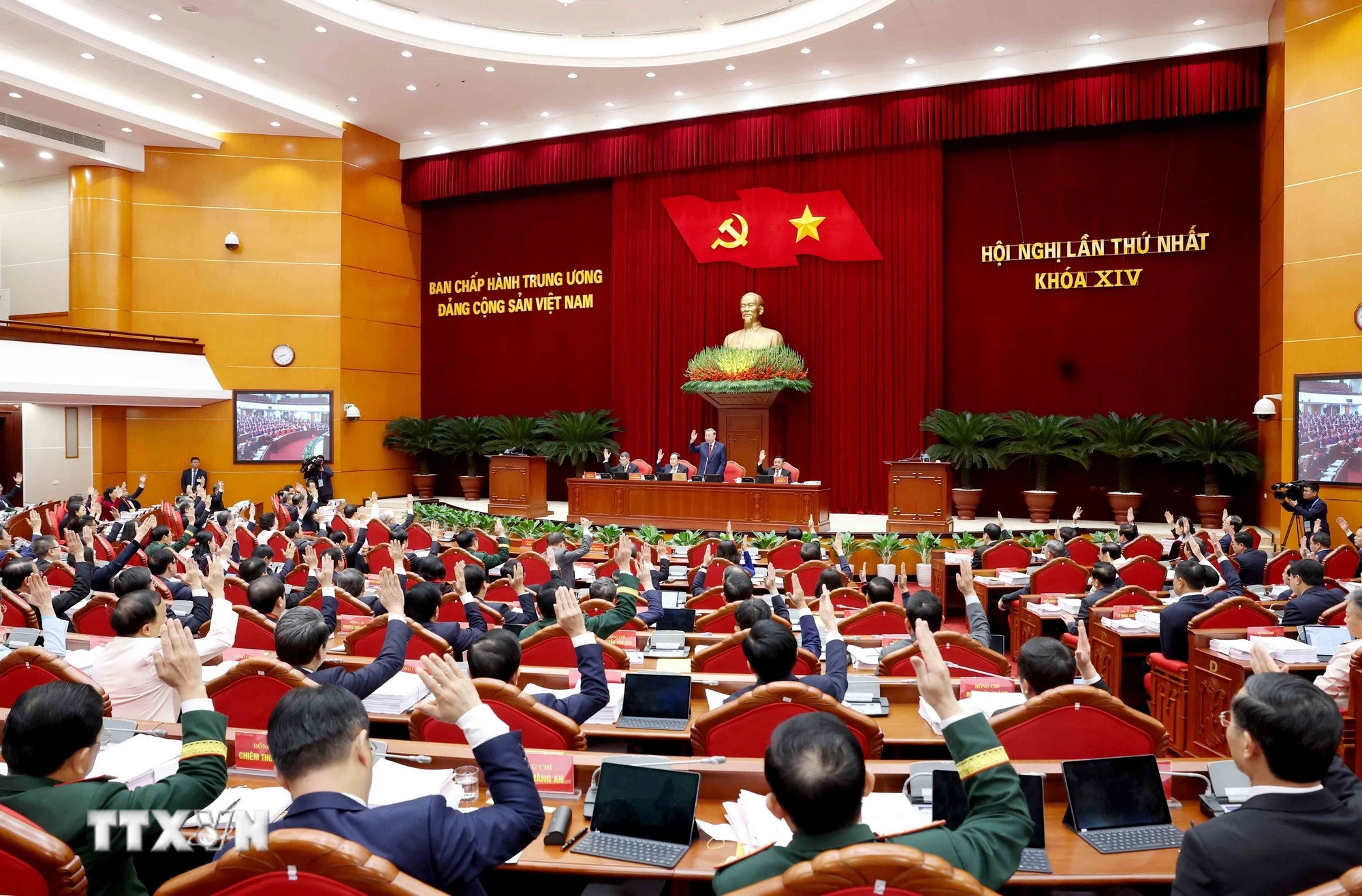 Các đồng chí Ủy viên Trung ương biểu quyết thông qua danh sách bầu Bộ Chính trị khóa XIV. (Ảnh TTXVN)