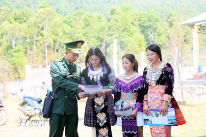 Cán bộ Đồn Biên phòng Mường Lèo (Ban Chỉ huy Bộ đội Biên phòng tỉnh Sơn La) tuyên truyền, vận động đồng bào dân tộc Mông ở bản Sam Quảng đi bầu cử. (Ảnh: Quang Quyết/TTXVN)