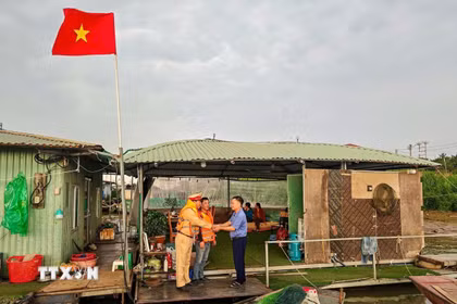 Đội Cảnh sát đường thủy số 2, Phòng Cảnh sát giao thông (Công an thành phố Hà Nội) đi từng xóm, đón từng thuyền, phát thẻ cử tri cho người dân trên sông Hồng. (Ảnh: TTXVN phát)